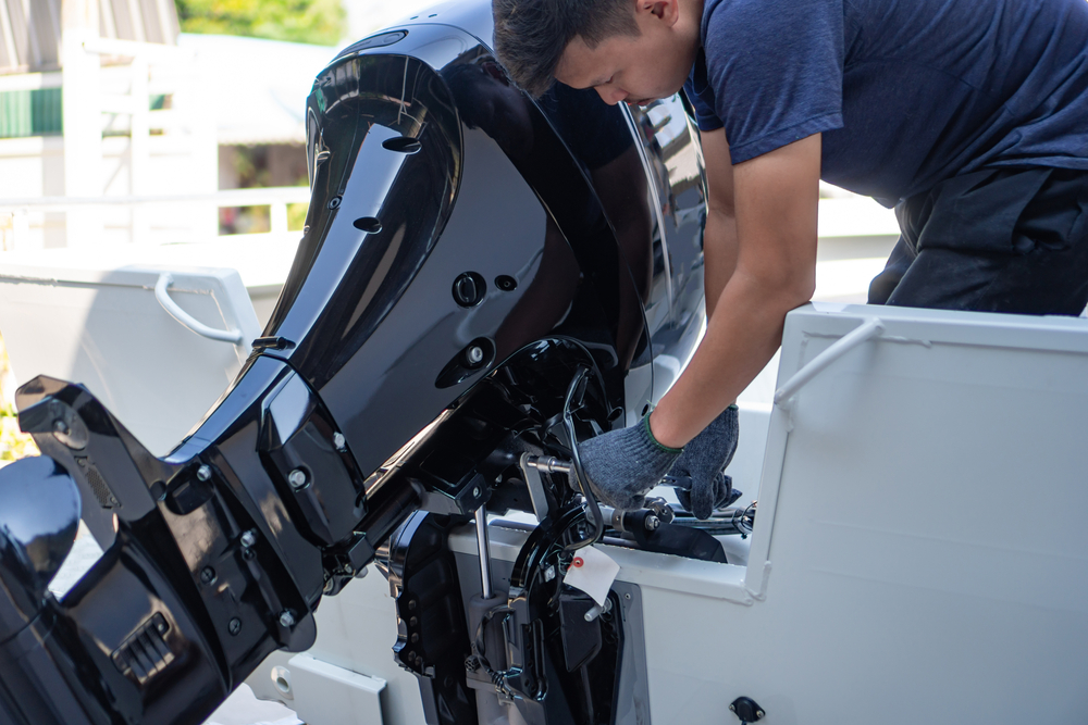 Marine mechanic servicing an outboard motor on a boat in Darwin